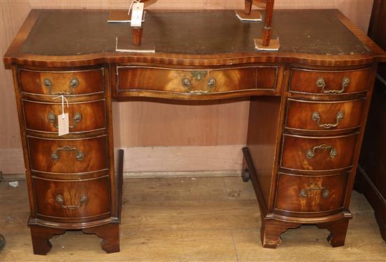 A George III style mahogany serpentine fronted desk, fitted nine drawers W.115cm